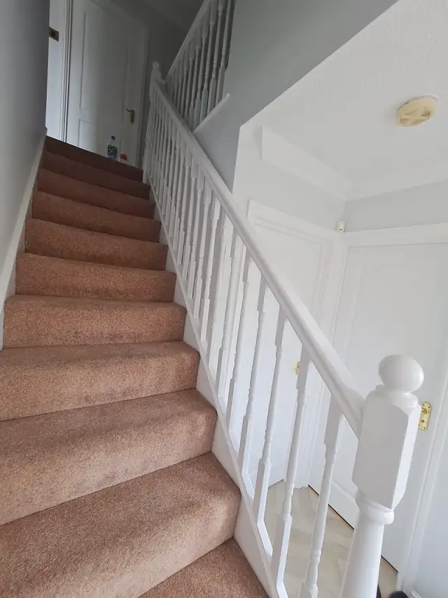 Staircase with white spindles and newel post