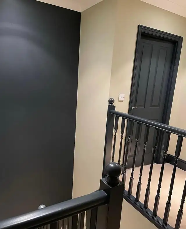 Landing with black painted spindles, handrail and door against cream walls